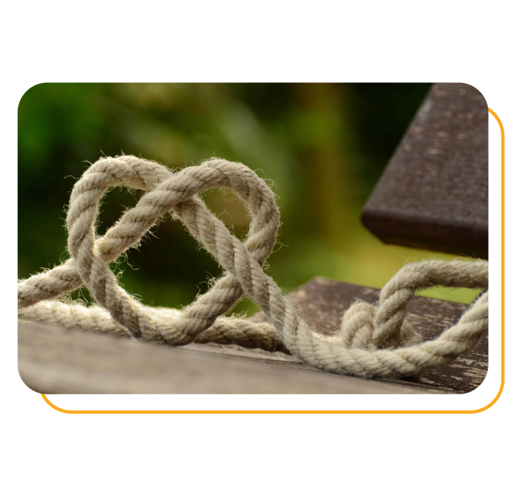 A rope tangled into heart shape on wooden board