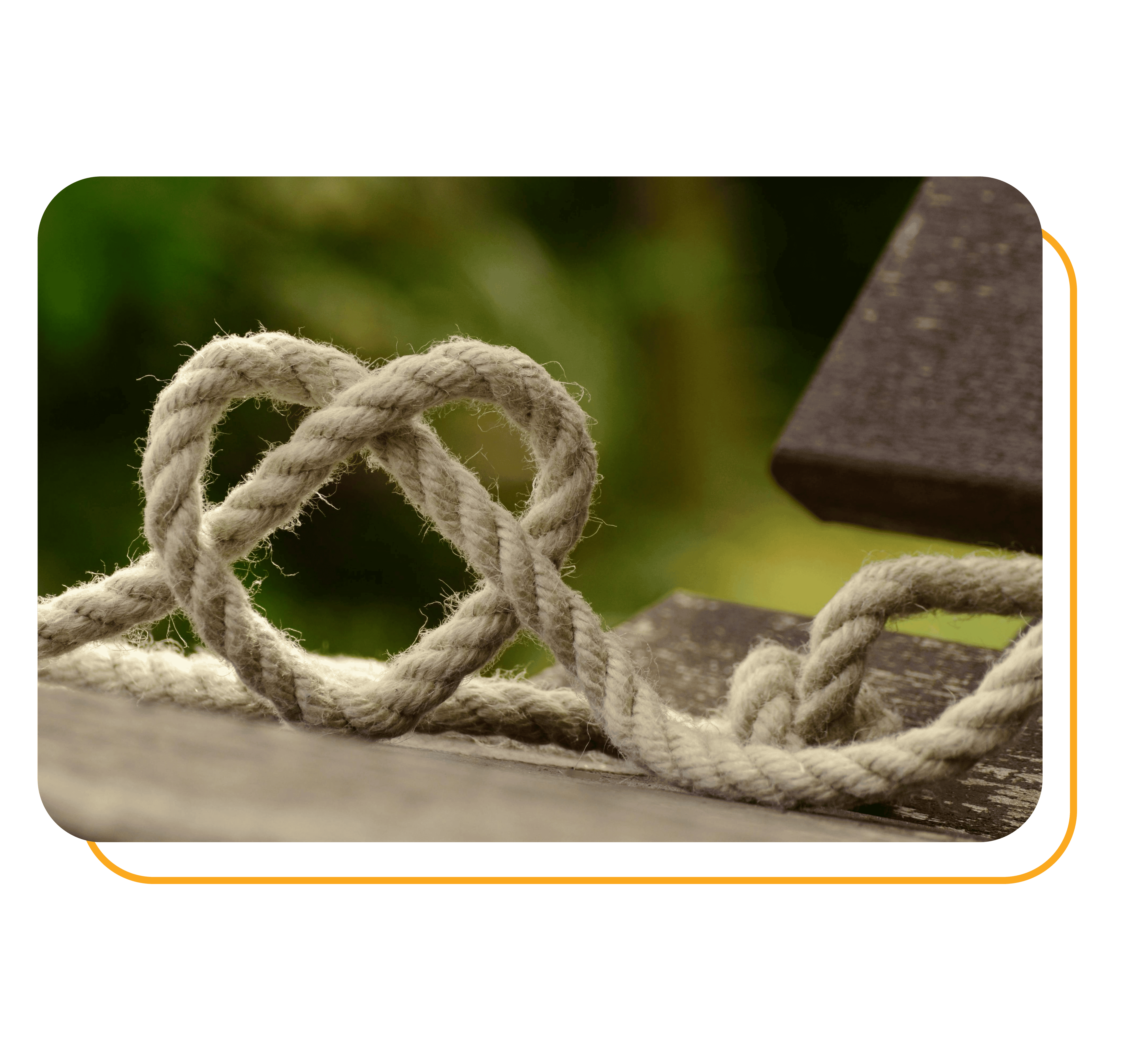 A rope tangled into heart shape on wooden board