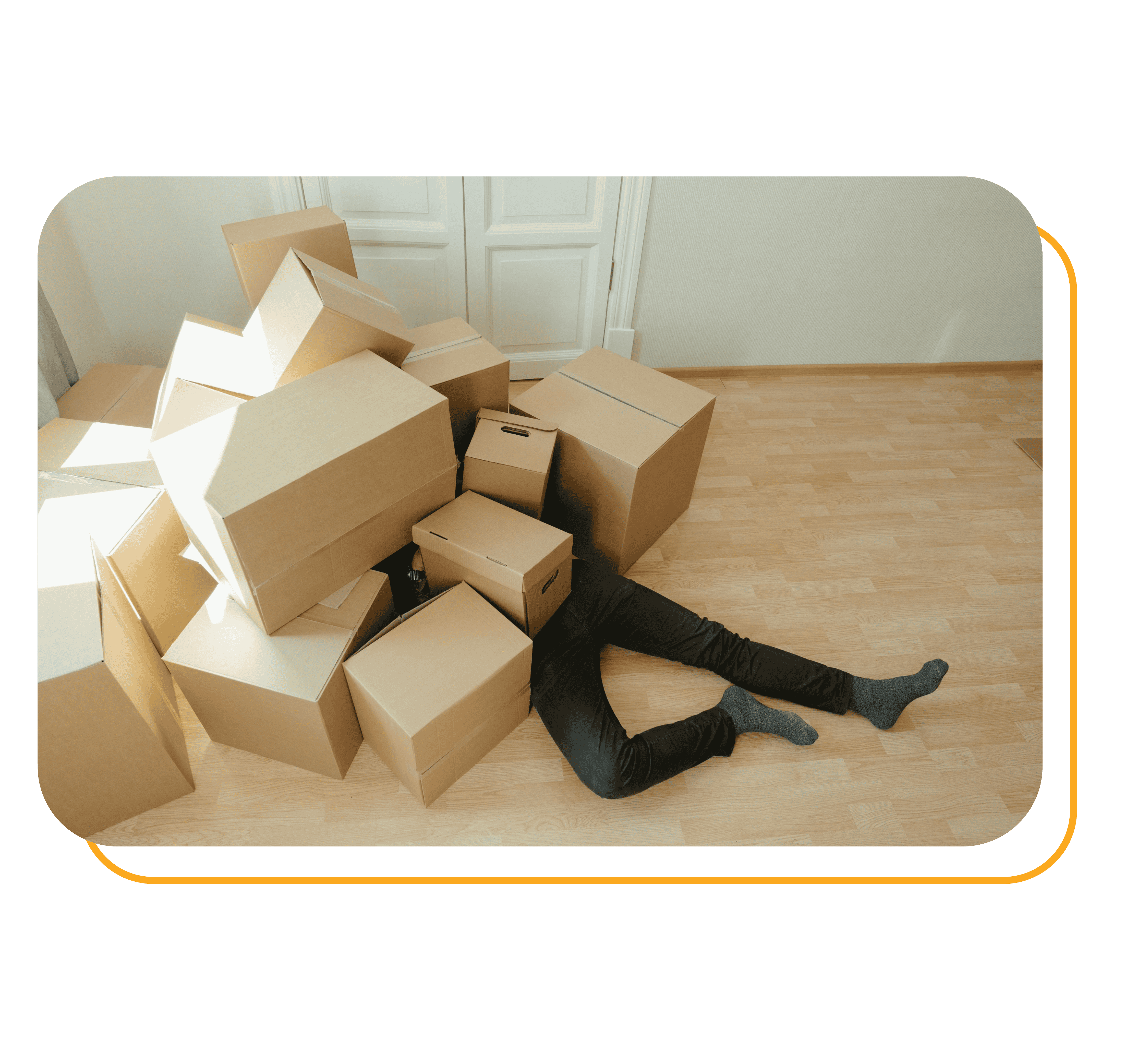 A person is lying under brown cardboard boxes