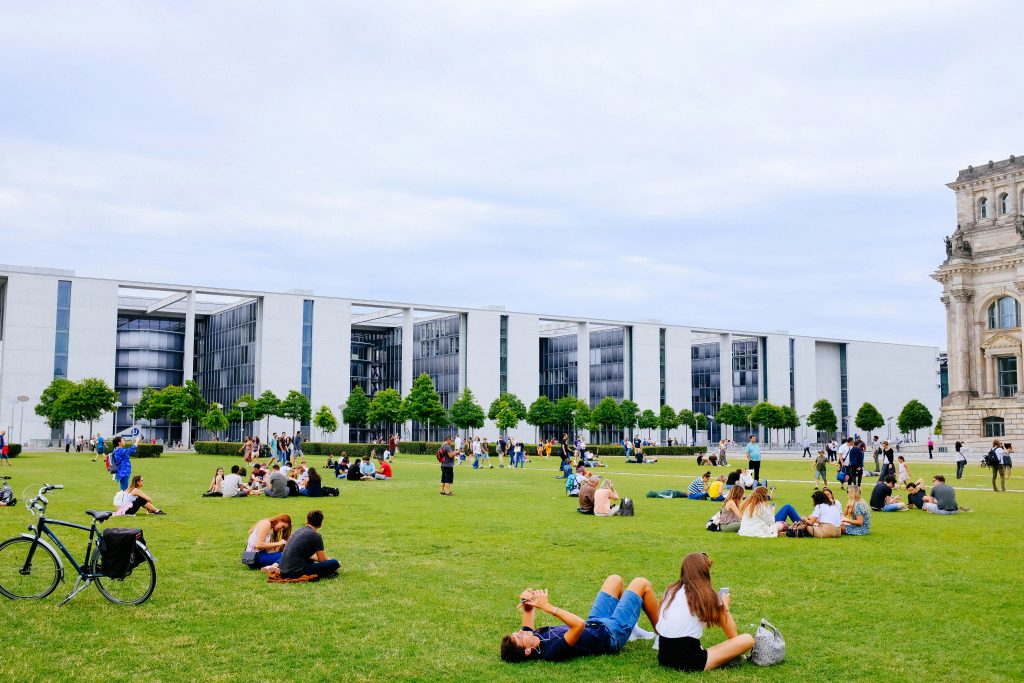 Students are sitting on the grass field